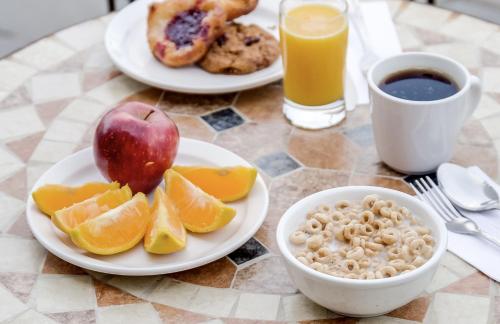 a table with plates of breakfast foods and a cup of coffee at Monte Carlo Inn Brampton in Brampton