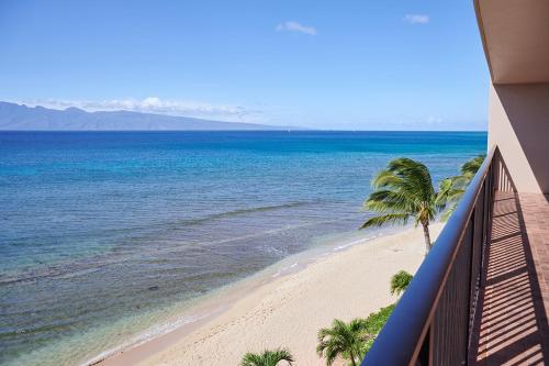 a balcony view of a beach with a palm tree at Aston Kaanapali Shores in Lahaina