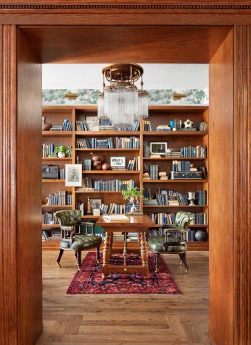 a library with a table and chairs and bookshelves at Graduate by Hilton New Haven in New Haven