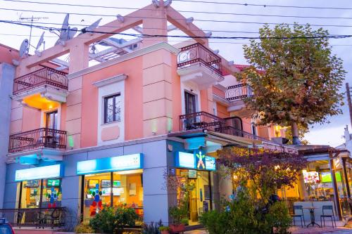 a pink building with balconies on a street at Yiannis Apartments in Ioannina