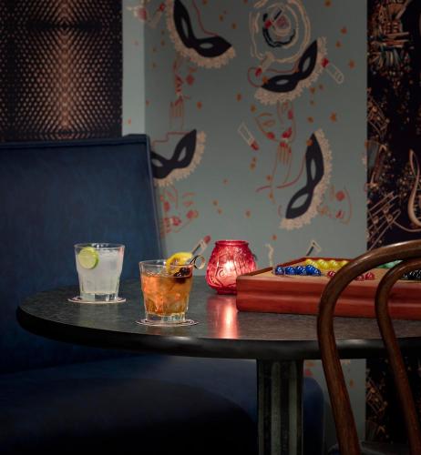 a table with two drinks and a vase on it at Graduate by Hilton New Haven in New Haven