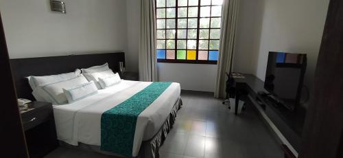 a bedroom with a large bed and a window at Hotel Union in Girardot