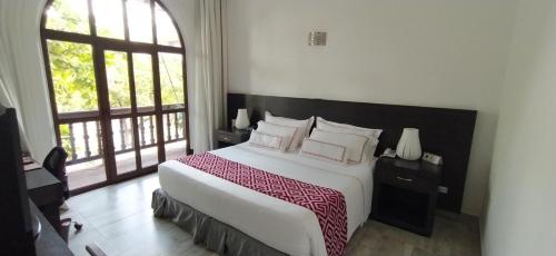 a bedroom with a large bed and a large window at Hotel Union in Girardot