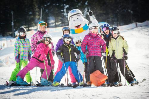 a group of children posing for a picture with a snowman at Résidence Les Grandes Feignes in La Bresse