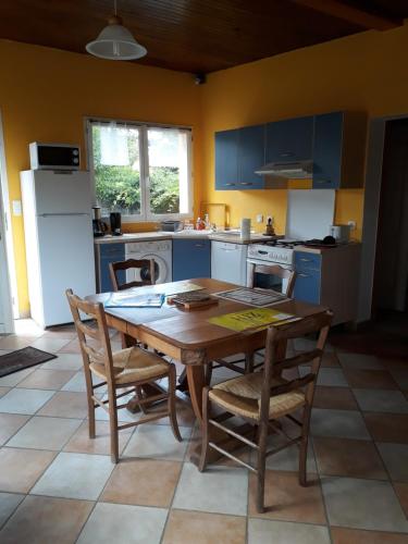 - une cuisine avec une table et des chaises en bois dans la chambre dans l'établissement Gite de Pêche, à Pont-de-Poitte