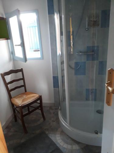 ein Badezimmer mit einer Dusche, einem Holzstuhl und einem Stuhl in der Unterkunft Gite de Pêche in Pont-de-Poitte
