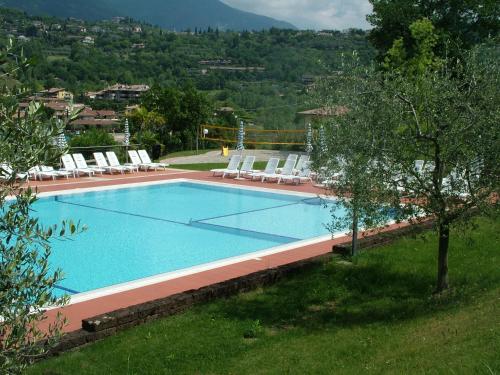 a large swimming pool with lounge chairs around it at Residence Corte Camaldoli in Garda