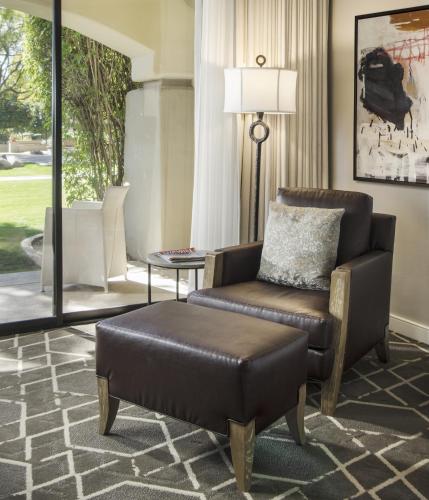 a living room with a chair and a ottoman at Fairmont Scottsdale Princess in Scottsdale