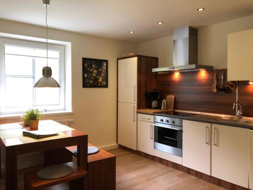 a kitchen with white cabinets and a table and a counter at Apartment Felswelten in Bielatal