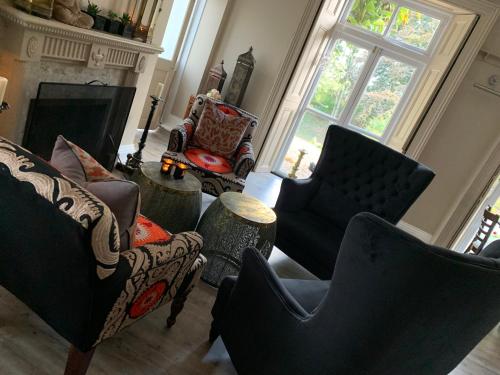 a living room with couches and chairs and a fireplace at Scarborough Hill Country Inn in North Walsham