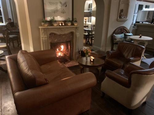 a living room with a couch and a fireplace at Scarborough Hill Country Inn in North Walsham