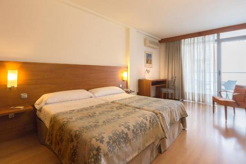 a bedroom with a large bed and a large window at Hotel Torre Monreal in Tudela