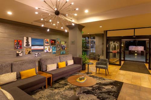 a living room with a couch and a chandelier at Silver Cloud Hotel - Seattle Broadway in Seattle