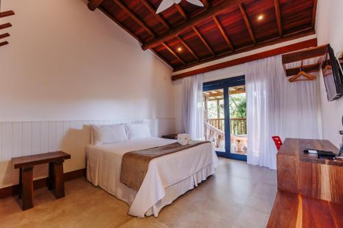 a bedroom with a bed and a large window at Pousada Alto da Pipa in Pipa