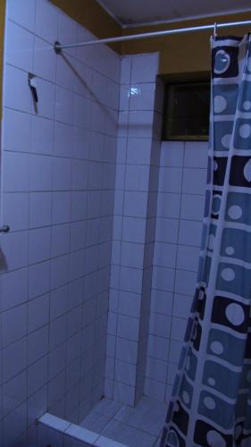 a bathroom with a white tiled shower with a ladder at Krusty Hostel B&B in Huaraz