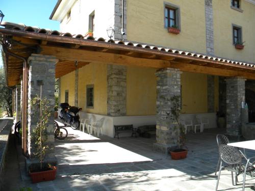 a patio of a building with a table and chairs at Giunasco in Bagnone
