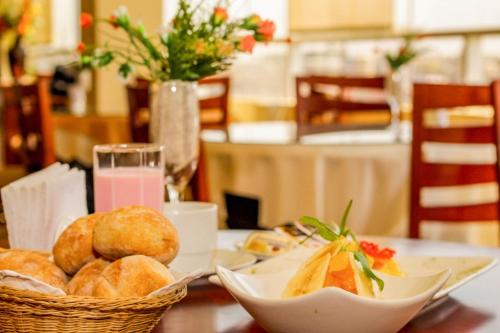 a table with a plate of bread and a glass of juice at Gran Hotel Ica in Ica