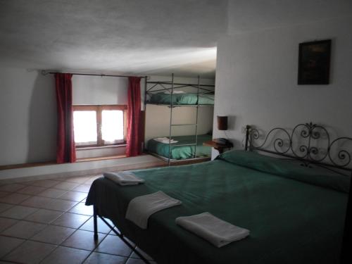 a bedroom with a green bed and a window at Giunasco in Bagnone