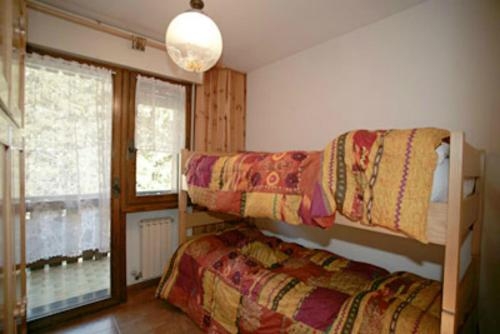 Ce dortoir comprend 2 lits superposés et une fenêtre. dans l'établissement Appartamenti Cercenà, à Canazei