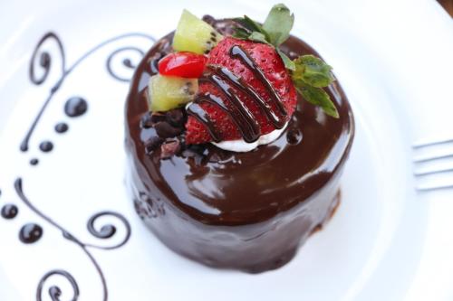 a chocolate dessert with strawberries and fruit on a plate at Hotel Nututun Palenque in Palenque