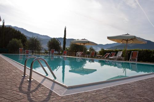 a large swimming pool with chairs and umbrellas at Giunasco in Bagnone