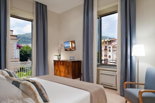 a bedroom with a bed and a large window at Grand Hotel Excelsior Vittoria in Sorrento