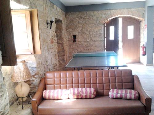 a leather couch in a living room with a table at Charming house in Alcobaça with mountain view in Alcobaça