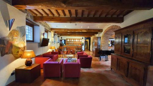 a large living room with red chairs and a couch at Relais La Corte di Bettona in Bettona