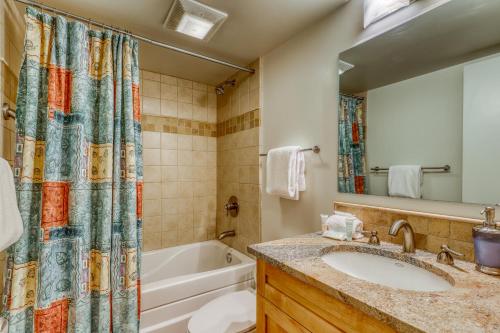 a bathroom with a sink and a tub and a shower curtain at Dollar Meadows 1388 in Sun Valley