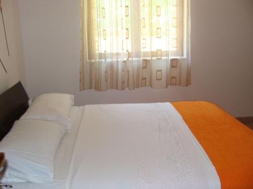 1 dormitorio con 1 cama y una ventana con cortinas blancas en Apartments Mana - 250 m from sea, en Split