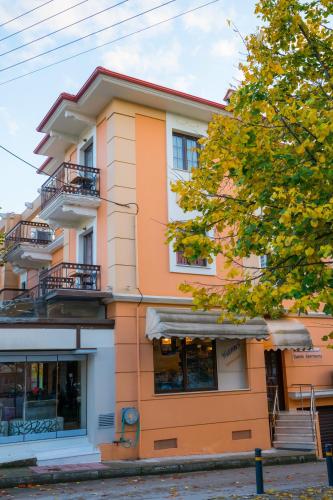 a orange building with a tree in front of it at Yiannis Apartments in Ioannina