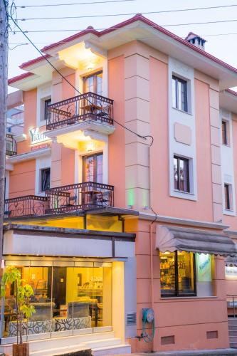 a pink and white building with windows at Yiannis Apartments in Ioannina