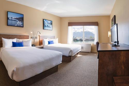 um quarto de hotel com duas camas e uma televisão em Harbor 360 Hotel Seward em Seward