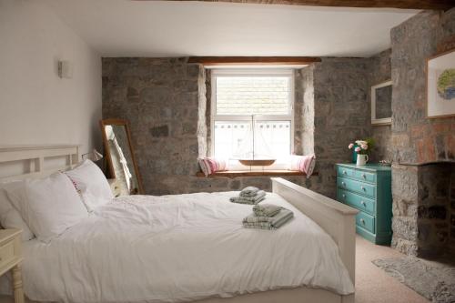 a bedroom with a white bed and a window at Teal House in Lyme Regis