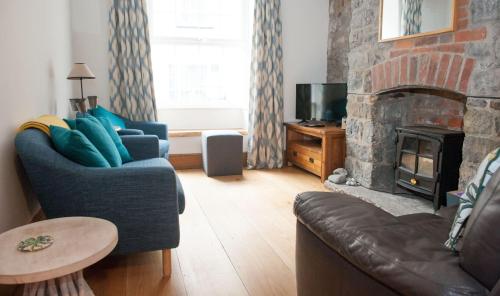 a living room with a couch and a fireplace at Teal House in Lyme Regis