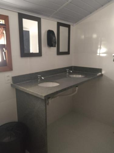 a bathroom with two sinks and two mirrors at HOSTEL DU SUCA in Petrópolis