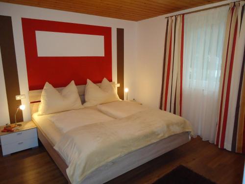 a bedroom with a large bed with a red painting on the wall at Haus Zerza in Dorfgastein