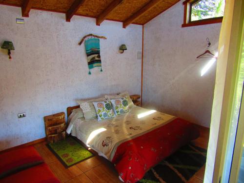 a bedroom with a bed in a room at Refugio de Montaña Kultrun Mawida, Cabaña Mirador in Curacautín