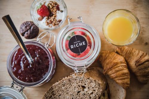 een tafel met brood, een pot jam en een glas sap bij Hotel Riche in Valkenburg
