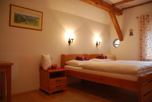 a bedroom with two beds and two lights on the wall at Farm Stay Rotovnik - Plesnik in Slovenj Gradec