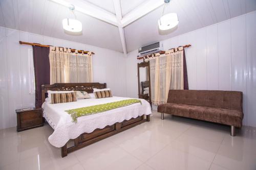 a bedroom with a large bed and a couch at Casa Boutique Blessed Place in San Andrés