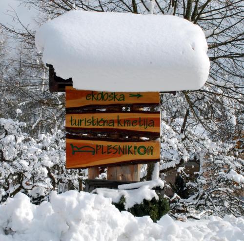 a sign in the snow with snow on it at Farm Stay Rotovnik - Plesnik in Slovenj Gradec