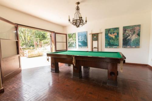 a room with a pool table and a chandelier at Hotel Casa Alpina in Núcleo Mauá