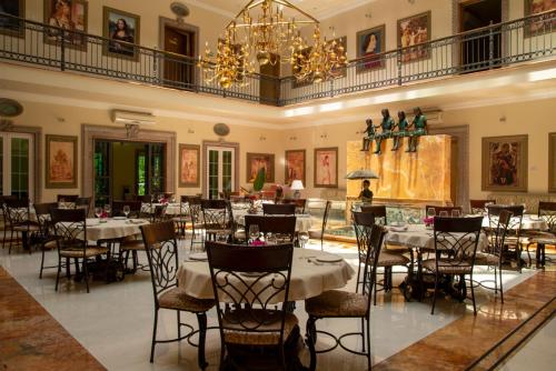 une salle à manger avec des tables et des chaises ainsi qu'un lustre dans l'établissement The Lorian Club, à Cocoyoc
