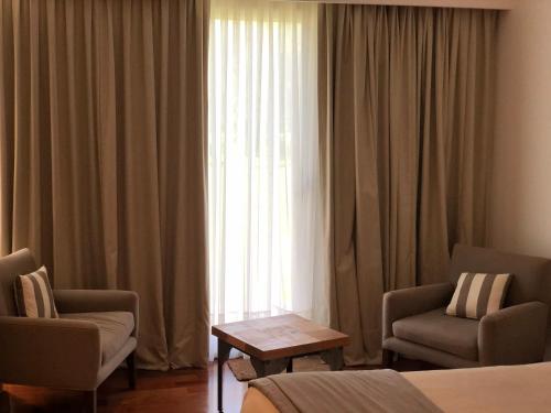 a hotel room with two chairs and a window at Noha Casa de Campo in Colón
