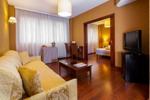 sala de estar con sofá, TV y mesa en Best Western Air Hotel Linate, en Segrate