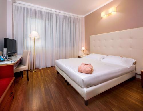 a hotel room with a large white bed and a desk at Best Western Air Hotel Linate in Segrate