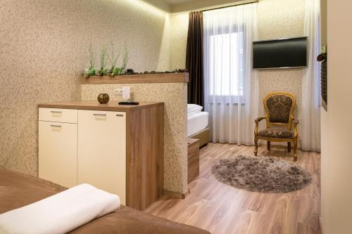 Habitación de hotel con cama, escritorio y silla en Főtér Rezidencia 3 en Győr