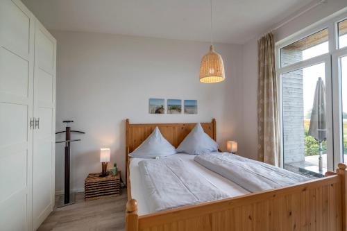 a bedroom with a large bed with a large window at Insel in Gelting