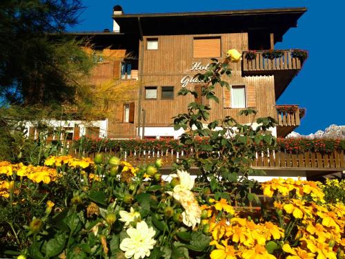 a garden of yellow flowers in front of a building at Hotel Giardino in Pieve di Cadore